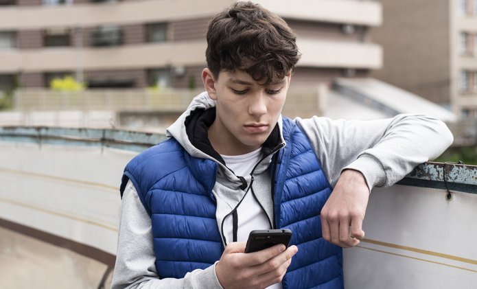 Teenage boy texting on a mobile phone